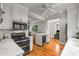 Well-lit kitchen featuring stainless steel appliances, white cabinetry, and a central island with hardwood floors at 4220 Club Ne Dr, Atlanta, GA 30319