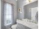 Charming bathroom featuring a marble vanity top and a window with patterned curtains at 1268 Windsor Glen Dr, Douglasville, GA 30134