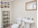 Half bathroom featuring a pedestal sink and toilet with a decorative mirror and shelving at 1268 Windsor Glen Dr, Douglasville, GA 30134