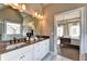 Bright bathroom with dual sinks, stone counters, and a glimpse into an airy bedroom with a decorative chandelier at 2852 Evanshire Ave # 114, Duluth, GA 30096