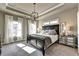 Main bedroom features tray ceilings, neutral paint, and large windows with white drapes at 2852 Evanshire Ave # 114, Duluth, GA 30096