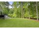 Expansive backyard with a lush lawn, patio, and steps leading to the upper deck, surrounded by trees at 660 Willow Knoll Se Dr, Marietta, GA 30067