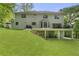 Backyard of the home featuring a patio, balcony, lush lawn, and mature trees providing privacy at 660 Willow Knoll Se Dr, Marietta, GA 30067
