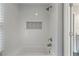 Bright bathroom featuring a white tiled bathtub with decorative tile accents and updated fixtures at 660 Willow Knoll Se Dr, Marietta, GA 30067