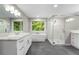 Bright bathroom with marble tile shower, soaking tub, double vanity, and picturesque window view at 660 Willow Knoll Se Dr, Marietta, GA 30067