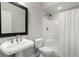 Clean bathroom with a pedestal sink, toilet, and shower with white shower curtain at 660 Willow Knoll Se Dr, Marietta, GA 30067