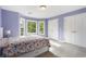Tranquil bedroom features three large windows, a patterned bedspread, and double closets for storage at 660 Willow Knoll Se Dr, Marietta, GA 30067