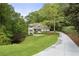 Stunning exterior view of a house with a long driveway and mature trees at 660 Willow Knoll Se Dr, Marietta, GA 30067