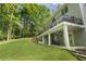 Exterior view of the home featuring a balcony, covered patio, and a well-maintained lawn surrounded by trees at 660 Willow Knoll Se Dr, Marietta, GA 30067