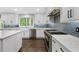 Bright white kitchen with stainless steel appliances, expansive countertops, and blue backsplash at 660 Willow Knoll Se Dr, Marietta, GA 30067