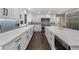 Modern white kitchen with a large island, stainless steel appliances, and blue backsplash at 660 Willow Knoll Se Dr, Marietta, GA 30067