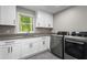 Laundry room featuring new front-loading appliances and white cabinets at 660 Willow Knoll Se Dr, Marietta, GA 30067