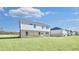 A two-story home showing brick and siding along with a spacious grassy backyard and blue sky at 108 Aj Welch Jr Way, Mcdonough, GA 30252