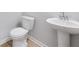 Functional half-bathroom with modern fixtures, white toilet and pedestal sink at 108 Aj Welch Jr Way, Mcdonough, GA 30252