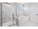 Bright bathroom features a glass shower, soaking tub and white marble tile at 124 Aj Welch Jr Way, Mcdonough, GA 30252