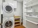 Organized laundry area features a stacked washer and dryer, plus shelving and storage at 1248 Conway Rd, Decatur, GA 30030