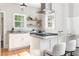 Granite countertops and stainless appliances enhance this kitchen with open shelving and pendant lighting at 1575 Linda Sw Way, Atlanta, GA 30310