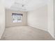 Large bedroom features plush carpeting, a ceiling fan, and a bright window at 1284 Charter Club Ct, Lawrenceville, GA 30043