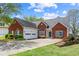 Charming brick home featuring an attached two-car garage, well-manicured lawn, and inviting curb appeal at 1284 Charter Club Ct, Lawrenceville, GA 30043