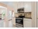 Modern kitchen showcasing stainless steel oven and microwave, complemented by granite countertops and white cabinets at 1284 Charter Club Ct, Lawrenceville, GA 30043