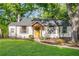 Charming home with a yellow door, shutters, and mature trees in a lush yard at 1611 Belmont Sw Ave, Atlanta, GA 30310