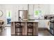 Bright kitchen featuring a gray island, granite counters, stainless steel appliances, and white cabinets at 1611 Belmont Sw Ave, Atlanta, GA 30310
