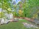 Expansive backyard featuring a wooden deck, lush green lawn, and mature trees at 5223 Hollyfield Dr, Stone Mountain, GA 30088