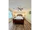 Relaxing bedroom with ceiling fan, wood floors, and natural light from a nearby window at 5223 Hollyfield Dr, Stone Mountain, GA 30088