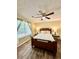 Bright bedroom featuring ceiling fan, wood floors, and natural light from a nearby window at 5223 Hollyfield Dr, Stone Mountain, GA 30088