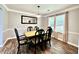 Bright dining area with a wood table, black chairs, modern light fixture, and a mirror, perfect for Gathering gatherings at 5223 Hollyfield Dr, Stone Mountain, GA 30088