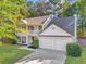 Charming two-story home featuring a well-manicured lawn, a two-car garage, and a welcoming front porch at 5223 Hollyfield Dr, Stone Mountain, GA 30088