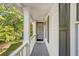 Charming front porch with white columns, grey floors, and a view of the front yard at 5223 Hollyfield Dr, Stone Mountain, GA 30088