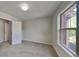 Neutral carpeted bedroom offers a window for natural light and a closet for storage at 1206 Kern Cv, Mcdonough, GA 30253