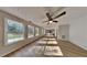 Spacious living room with a ceiling fan, large windows, and new flooring at 1206 Kern Cv, Mcdonough, GA 30253