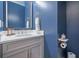 Stylish powder room with a marble countertop, modern fixtures, and a trendy blue wall color at 126 Abbington River Ln, Atlanta, GA 30339