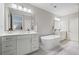 This bathroom features double vanities, a large soaking tub, neutral wall color, and nice natural light at 126 Abbington River Ln, Atlanta, GA 30339