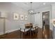 Dining area featuring modern chandelier, dining table and chairs, and dark hardwood flooring at 126 Abbington River Ln, Atlanta, GA 30339
