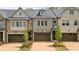 Charming townhome exterior featuring mixed brick and stone facade with well-manicured landscaping and attached garages at 126 Abbington River Ln, Atlanta, GA 30339