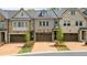 Charming townhome showcasing a two-car garage, beautiful landscaping, and stone accents at 126 Abbington River Ln, Atlanta, GA 30339