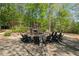 Outdoor stone firepit with seating area surrounded by mature trees and landscaping at 126 Abbington River Ln, Atlanta, GA 30339