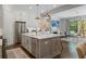Open concept kitchen with stainless steel appliances, gray island, white cabinetry, and adjacent living space at 126 Abbington River Ln, Atlanta, GA 30339