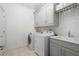 Well-equipped laundry room with modern washer, dryer, and sink, plus ample storage cabinets at 126 Abbington River Ln, Atlanta, GA 30339