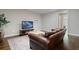 Cozy living room featuring a leather sofa, patterned rug, and large TV for entertainment at 126 Abbington River Ln, Atlanta, GA 30339