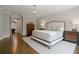 Spacious main bedroom with hardwood floors, decorative lighting, and a dresser for ample storage at 126 Abbington River Ln, Atlanta, GA 30339