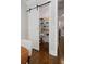 Pantry with sliding barn door revealing shelving stocked with food and other home items at 126 Abbington River Ln, Atlanta, GA 30339