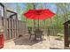 Outdoor patio area featuring a table with chairs under a red umbrella, and privacy fence at 126 Abbington River Ln, Atlanta, GA 30339