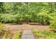 Serene backyard with lush greenery and a stone path, creating a tranquil outdoor space at 2175 Eagle Trce, Cumming, GA 30040