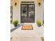 Welcoming front door with glass panels, flanked by potted flowers and a 'Welcome' mat on a covered porch at 2175 Eagle Trce, Cumming, GA 30040