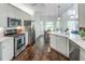 Modern kitchen with stainless steel appliances, white cabinets, hardwood floors, and natural light from surrounding windows at 2175 Eagle Trce, Cumming, GA 30040
