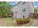 View of the home's rear exterior, featuring a wood deck and landscaped backyard with orange bushes and a rock border at 2311 Norbury Se Cv, Smyrna, GA 30080